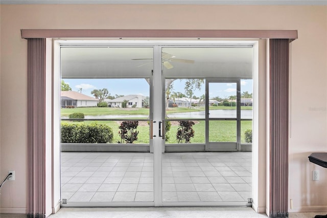 doorway to outside with ceiling fan and a water view