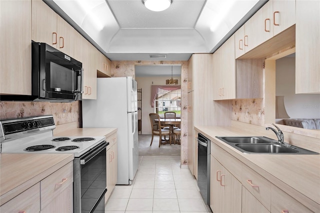 kitchen featuring light tile patterned flooring, light brown cabinetry, sink, and black appliances