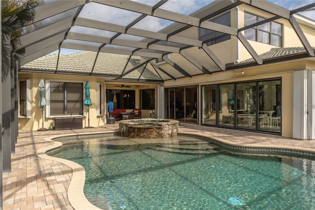 view of pool featuring a patio, a lanai, a pool with connected hot tub, and a ceiling fan