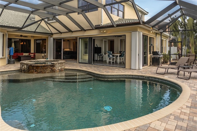 view of pool featuring a grill, a lanai, a patio area, ceiling fan, and an in ground hot tub