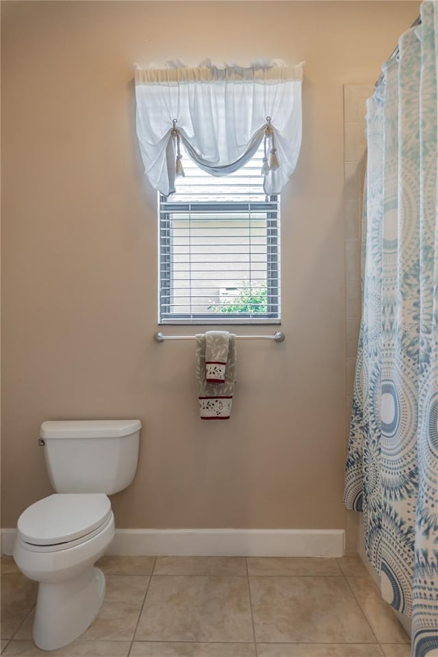 bathroom featuring toilet, walk in shower, and tile patterned floors