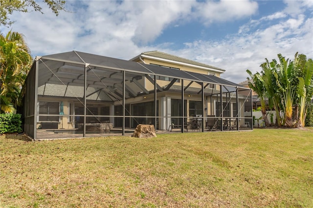 rear view of house featuring a lawn, a patio area, and glass enclosure