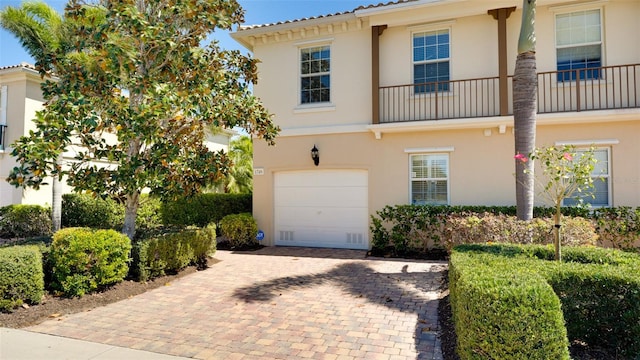 view of front of property featuring a balcony and a garage