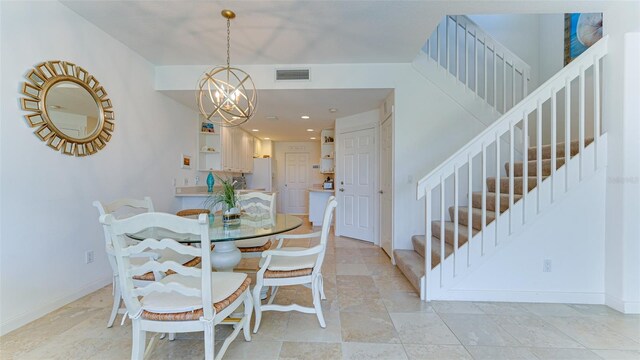 tiled dining room featuring an inviting chandelier