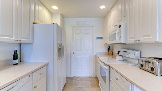 kitchen with white appliances, white cabinets, and light tile floors