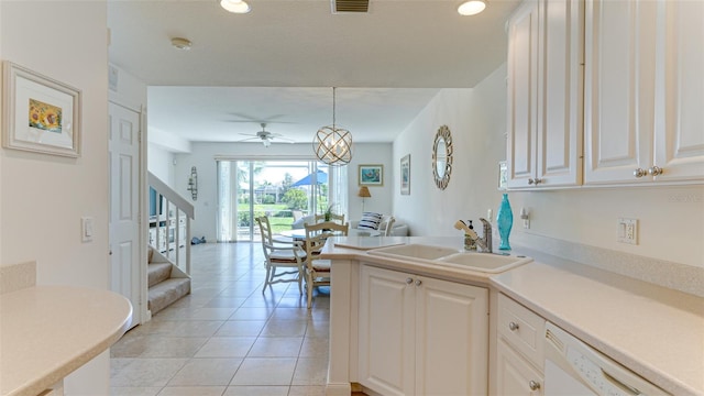 kitchen with light tile flooring, ceiling fan with notable chandelier, white cabinetry, and sink