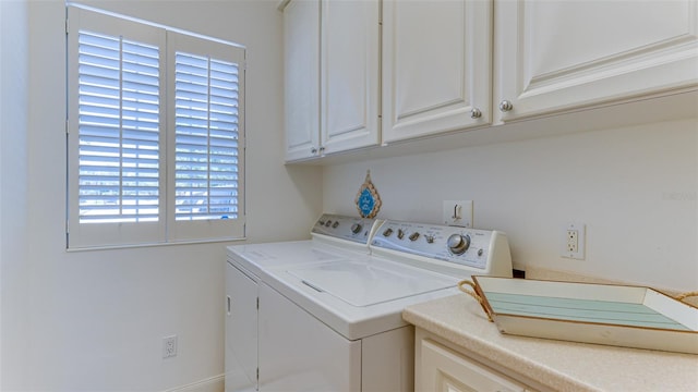 laundry area featuring washing machine and dryer and cabinets