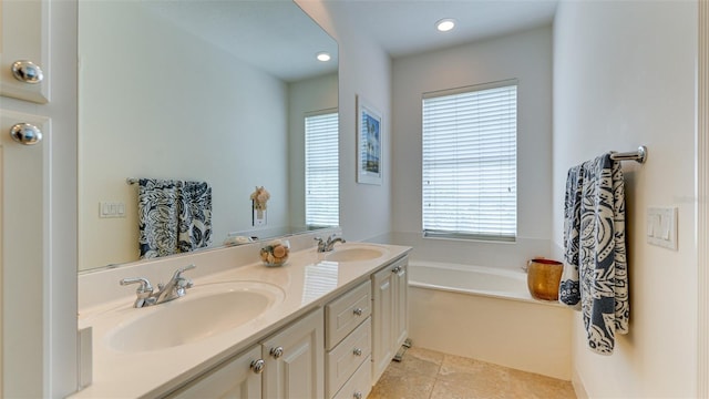 bathroom with oversized vanity, tile floors, a bath, and dual sinks