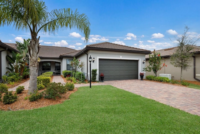 mediterranean / spanish house featuring a garage and a front yard