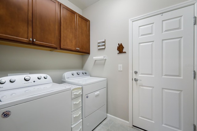 laundry area featuring cabinets, separate washer and dryer, and light tile patterned floors