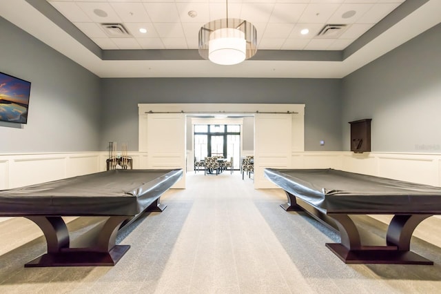 game room featuring a tray ceiling, a barn door, light carpet, and pool table