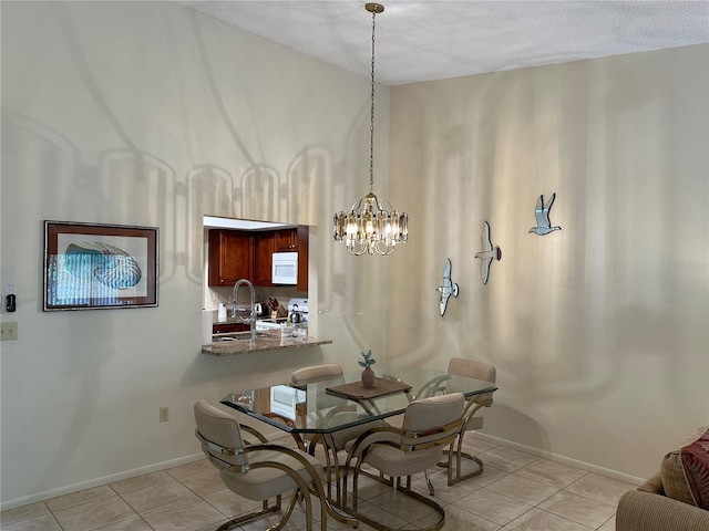 tiled dining room featuring a textured ceiling and an inviting chandelier