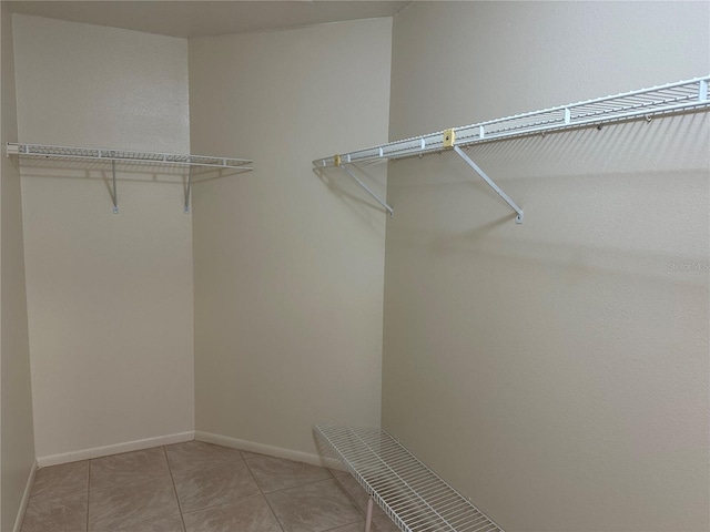 walk in closet featuring light tile floors