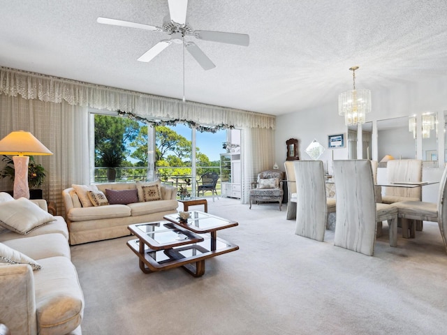 carpeted living room with a textured ceiling and ceiling fan with notable chandelier