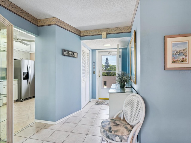 corridor with light tile patterned floors and a textured ceiling