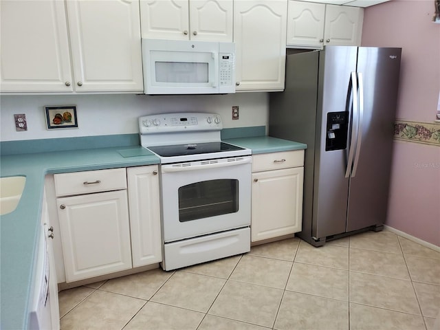 kitchen with white cabinetry, light tile patterned floors, and white appliances