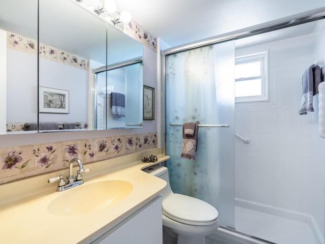 bathroom with vanity, a shower with shower door, and toilet