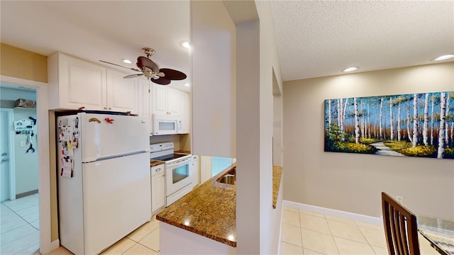 kitchen featuring white cabinetry, ceiling fan, dark stone counters, white appliances, and light tile patterned floors