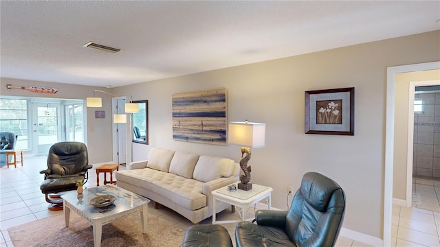 living room with a textured ceiling and light tile patterned flooring