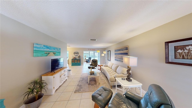 living room featuring a textured ceiling and light tile patterned flooring