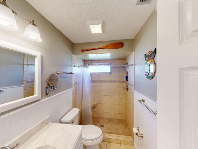 bathroom with tile patterned floors, vanity, toilet, and curtained shower