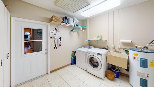 clothes washing area with electric water heater, sink, light tile patterned flooring, and independent washer and dryer