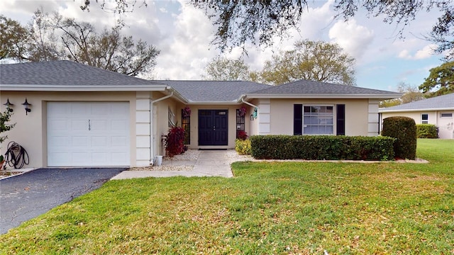 ranch-style house featuring a garage and a front lawn