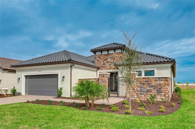 mediterranean / spanish-style house featuring a garage and a front yard