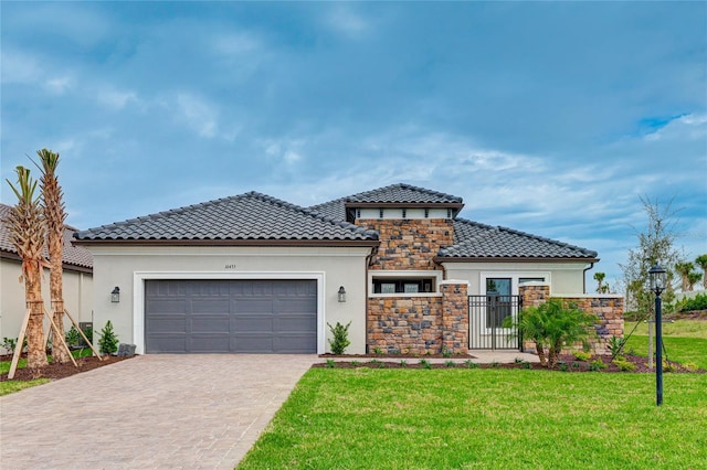 mediterranean / spanish-style home with a garage and a front lawn