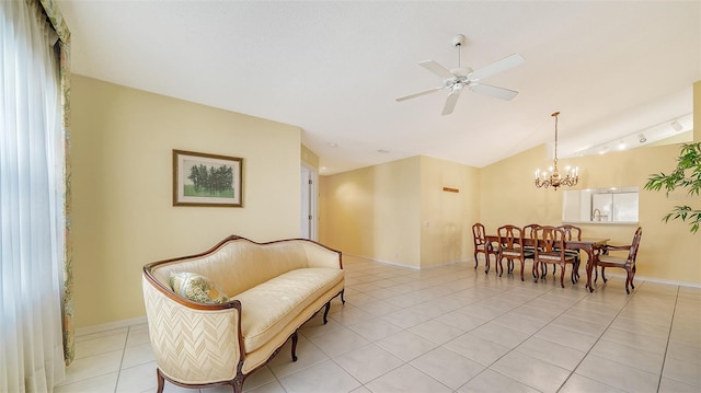 living area featuring lofted ceiling, track lighting, light tile floors, and ceiling fan with notable chandelier