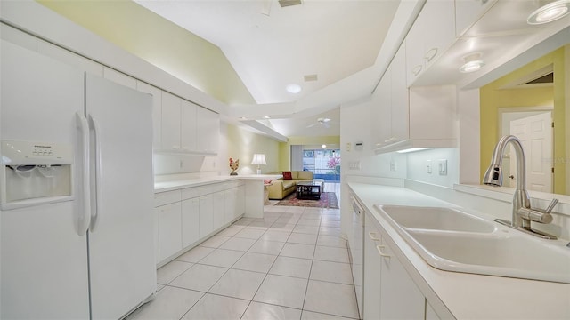 kitchen with white refrigerator with ice dispenser, vaulted ceiling, white cabinets, and sink