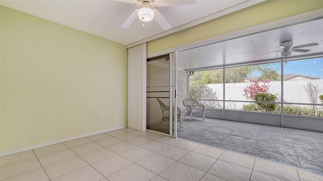 spare room featuring light tile floors and ceiling fan