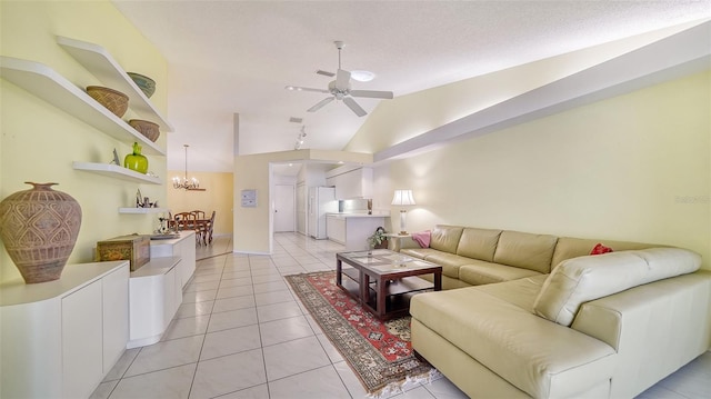 tiled living room featuring ceiling fan with notable chandelier and vaulted ceiling