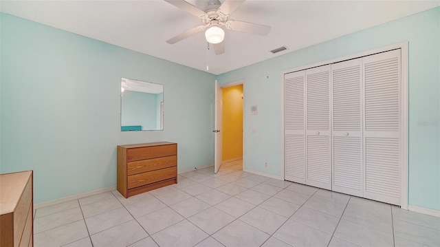 unfurnished bedroom with a closet, ceiling fan, and light tile floors