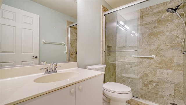 bathroom with toilet, an enclosed shower, and vanity