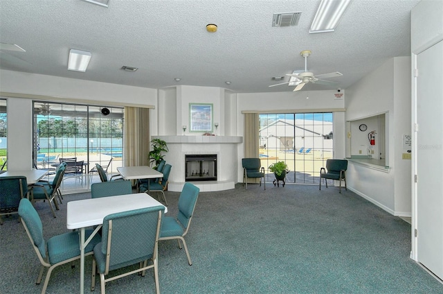 carpeted dining space featuring a textured ceiling and ceiling fan