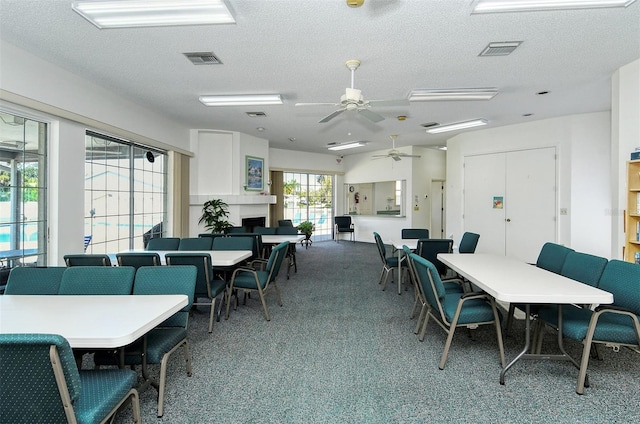 dining area with a textured ceiling, ceiling fan, and carpet floors