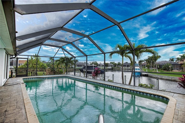 view of swimming pool with a patio area, glass enclosure, and a water view