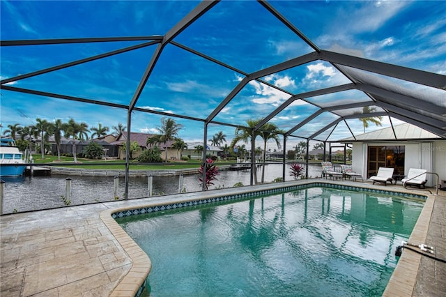 view of swimming pool with a water view, glass enclosure, and a patio