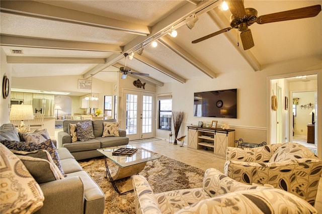 tiled living room with ceiling fan, french doors, vaulted ceiling with beams, and a textured ceiling