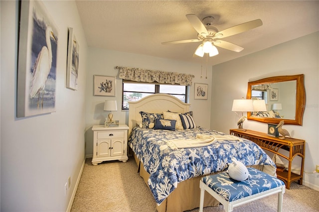 bedroom with a textured ceiling, light colored carpet, and ceiling fan