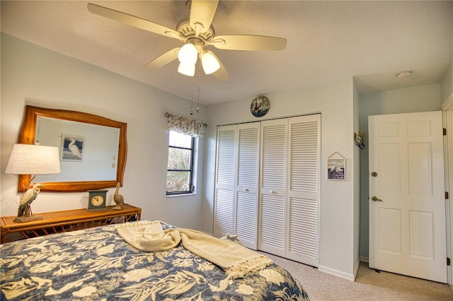 carpeted bedroom with a textured ceiling, a closet, and ceiling fan