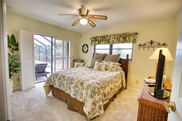 bedroom with multiple windows, access to exterior, light colored carpet, and a textured ceiling