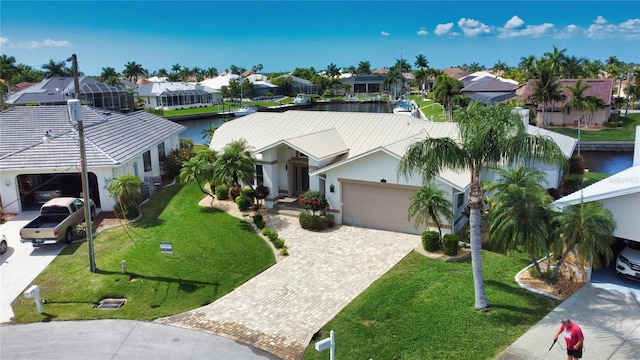 view of front facade featuring a water view, a front yard, and a garage