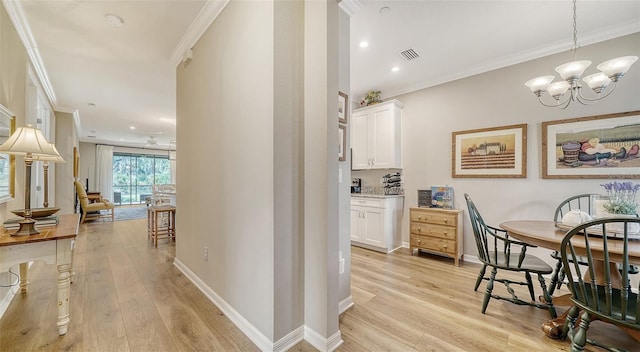 interior space featuring an inviting chandelier, light hardwood / wood-style floors, and ornamental molding