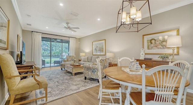 dining area featuring crown molding, light hardwood / wood-style floors, and ceiling fan with notable chandelier