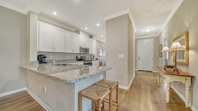 kitchen with light hardwood / wood-style floors, stainless steel appliances, and white cabinetry