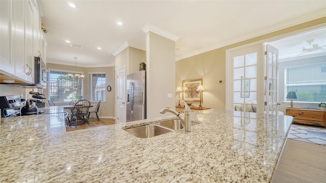 kitchen with white cabinets, stainless steel appliances, light wood-type flooring, and sink