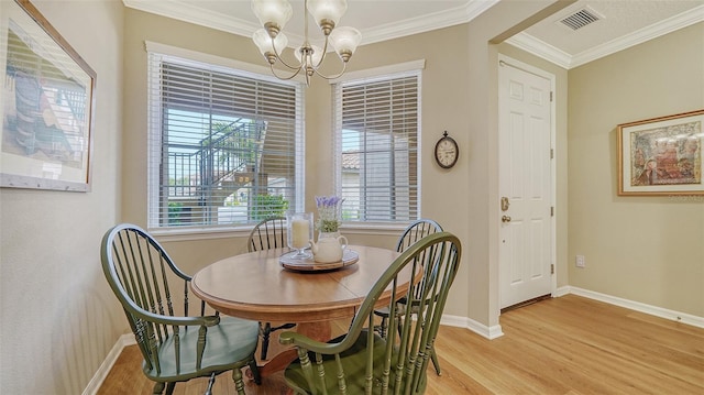 dining space with a notable chandelier, crown molding, and light hardwood / wood-style floors