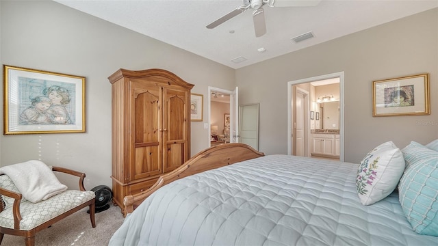 carpeted bedroom with ensuite bath and ceiling fan